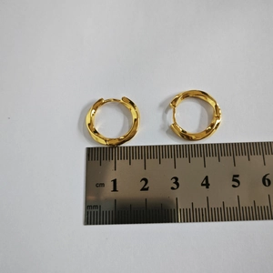 Dettaglio degli orecchini a cerchio dorati a spirale da 1,8 cm con righello graduato