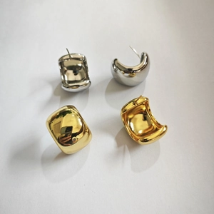 Close-up of chunky D-shape geometric hoop earrings in polished gold and silver finish