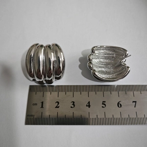 Mesure détaillée des boucles d'oreilles argentées nervurées en C avec une règle graduée