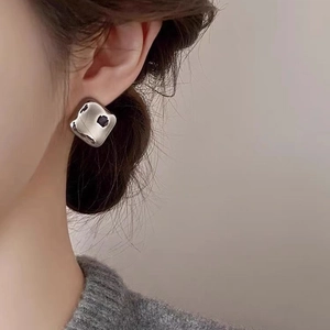 Boucles d'oreilles carrées irrégulières en argent avec texture de lave sur modèle