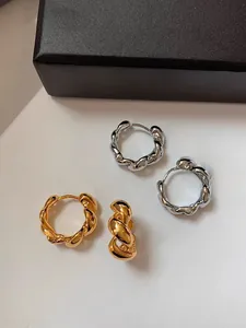 Vue détaillée de créoles torsadées en finitions or et argent avec texture corde