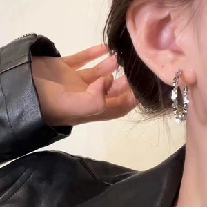 Sleek silver-toned hoop earrings with sparkling texture worn with a black leather jacket