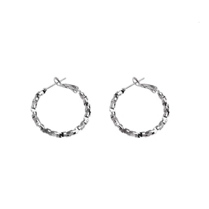 Polished silver hoop earrings with textured geometric facets and minimalist luxury style