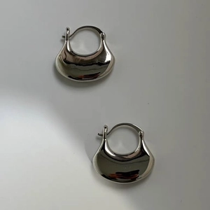 Detailed view of chunky silver teardrop earrings with a high-polished mirror finish