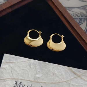 Polished gold crescent earrings on dark velvet, minimalist and modern fashion jewelry