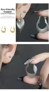 Détail de boucles d'oreilles citron en cuivre écologique avec texture tissée or et argent