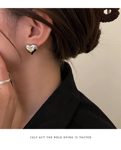 Close-up of model wearing a 3D heart-shaped silver stud earring with polished mirror finish