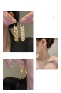 Detail view of gold tassel earrings with cascading chains on model for elegant style