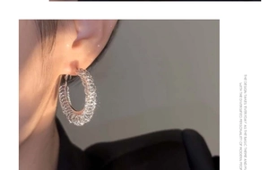 Close-up of S925 silver hoop earrings with textured finish on model showing sparkling details