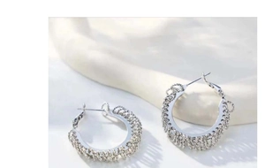 Macro shot of S925 silver hoop earrings with dense woven texture and polished finish