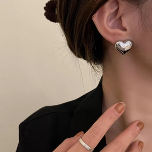 Three-dimensional S925 silver heart stud earring shown on model for elegant style