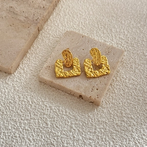 Irregular hammered geometric 18K gold plated earrings on natural stone background