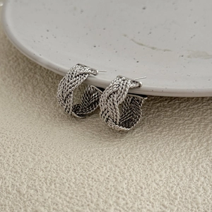Silver twisted woven knot stud earrings with textured metallic spiral design for women