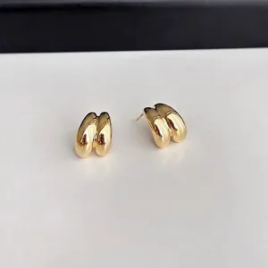 Detailopname van gouden druppelvormige oorknopjes met een gepolijste hoogglans metalen finish