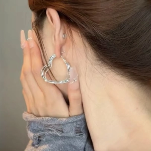 Chic silver hollow heart hoop earrings featuring a polished metallic finish on model