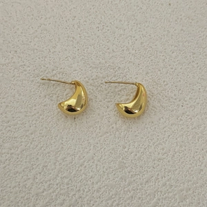 Makroaufnahme polierter goldener Halbmond-Ohrringe mit glattem Spiegelglanz-Finish
