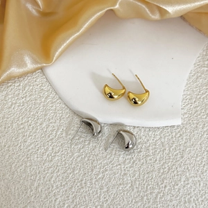 Nahaufnahme minimalistischer geometrischer Ohrstecker in Gold und Silber mit Glanzeffekt