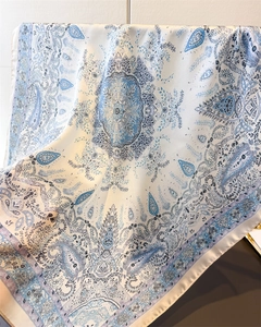 Detailed view of silk square scarf featuring elegant blue paisley and mandala patterns