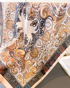 Close-up of elegant paisley print silk scarf with luxury satin texture and rich warm tones