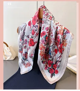 Detailed close-up of floral print silk scarf hanging on a wooden hanger with chic accessories