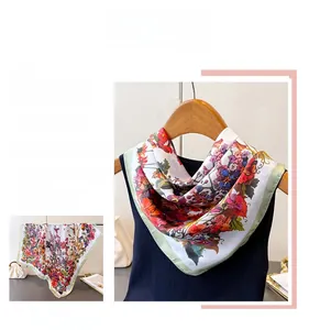 Detail of elegant floral silk scarf with vibrant orange and purple blossoms on dark base