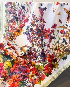 Detail of silk satin scarf featuring vibrant floral prints and butterfly patterns