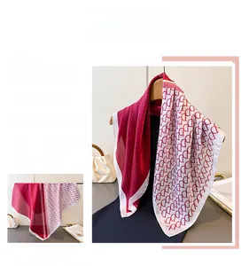 Detail of red and ivory silk scarf featuring elegant interlocking D-letter patterns