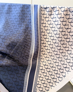 Detail of luxury silk square scarf with blue and beige monogram letter pattern print