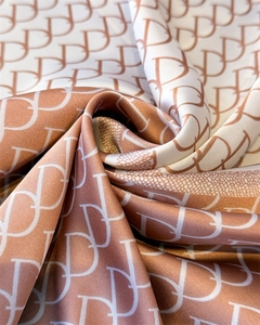 Macro shot of satin silk scarf featuring bicolor geometric logo print and elegant texture