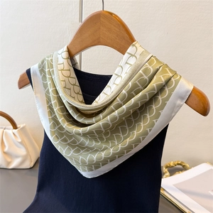 Elegant green and white square silk scarf with geometric D-pattern on a wooden hanger