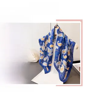 Detail of blue paisley silk scarf showing elegant glossy texture and intricate pattern