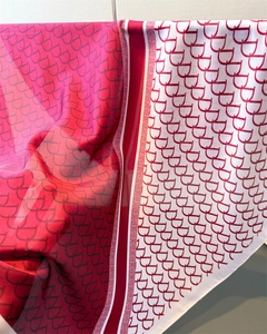 Close-up of deep red and white monogram print silk scarf with luxury textured folds