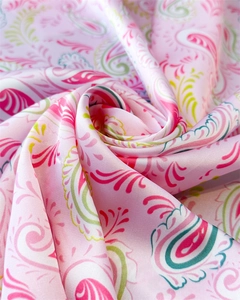 Detail of pink paisley silk scarf showing smooth satin texture and colorful floral pattern