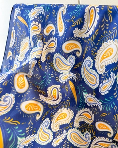 Detailed macro view showing paisley print texture and silk fabric folds of the scarf