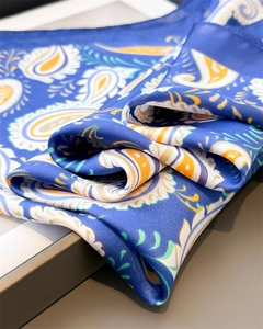 Macro shot of paisley pattern silk scarf with silky blue satin texture and luster