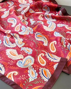 Detail of red paisley satin scarf showing smooth silky texture and intricate print