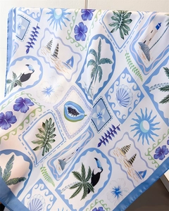 Detailed view of island style silk-like scarf with palm leaves and floral patterns