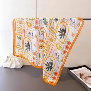 Detail of printed silk scarf with tropical palm trees and toucans in vibrant orange tones