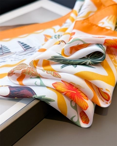 Detail of tropical print silk scarf featuring toucan and nautical boat patterns