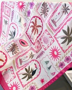 Detail of tropical print silk scarf featuring hibiscus flowers and palm trees texture