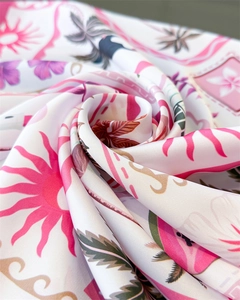 Macro view of silky floral print scarf with pink sunburst and green palm leaves