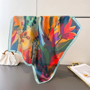 Close-up of vibrant sunflower oil painting print on silky floral square scarf detail