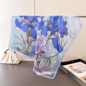 Elegant blue oil painting style silk scarf with iris print draped on a metal hanger