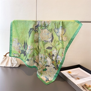 Detailed close-up of green oil painting silk scarf with white floral print edges
