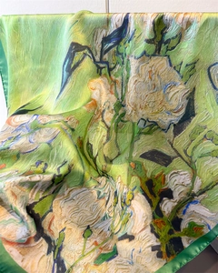 Close-up of silk scarf showing floral oil painting print and smooth satin texture