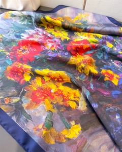 Detail view of floral oil painting pattern on smooth silk scarf with navy blue border