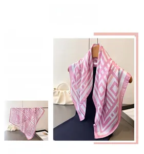 Detail of pink and white geometric silk scarf draped on a hanger with satin texture