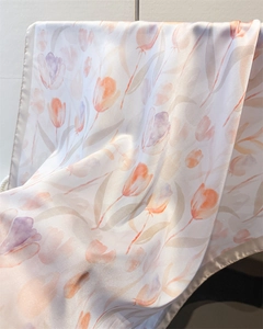 Close-up of translucent tulip print silk scarf showing soft texture and satin edge finish