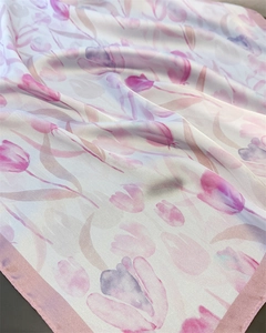 Close-up of elegant tulip print on a white silk scarf with soft fabric folds