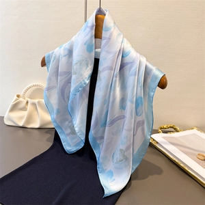 Elegant light blue silk-like square scarf with purple tulip floral print on a hanger